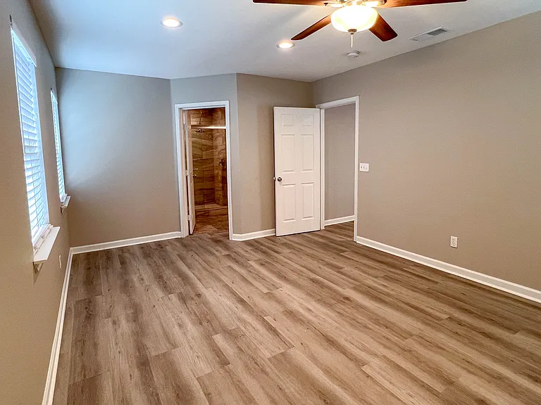 Primary bedroom has direct access to the private bath, featuring updated finishes just beyond the doorway.