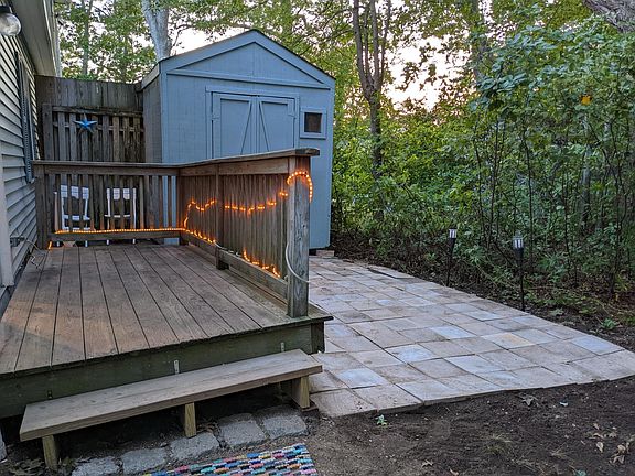 Backyard with patio, deck, and shed.