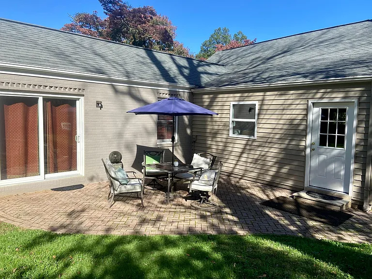 Outside large patio area with 2 tables and umbrellas