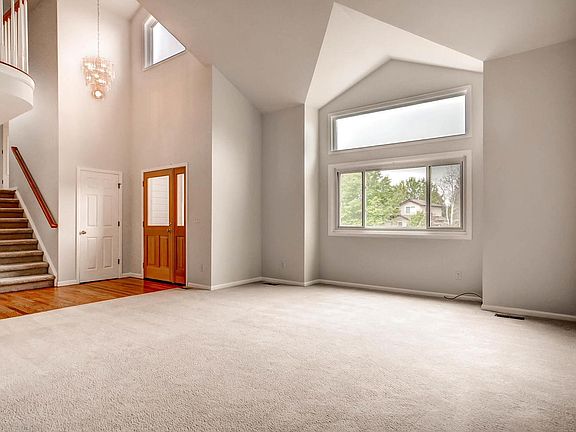 Living room, front door, and stairs leading to upper floor bedroom and balcony