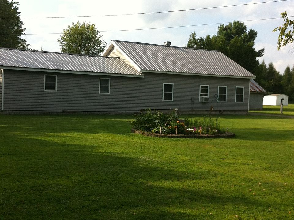 Front of house showing flowerbed in center of yard