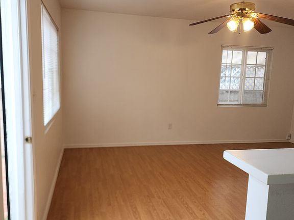 Large living room open to kitchen area with easy to keep clean laminate wood flooring.