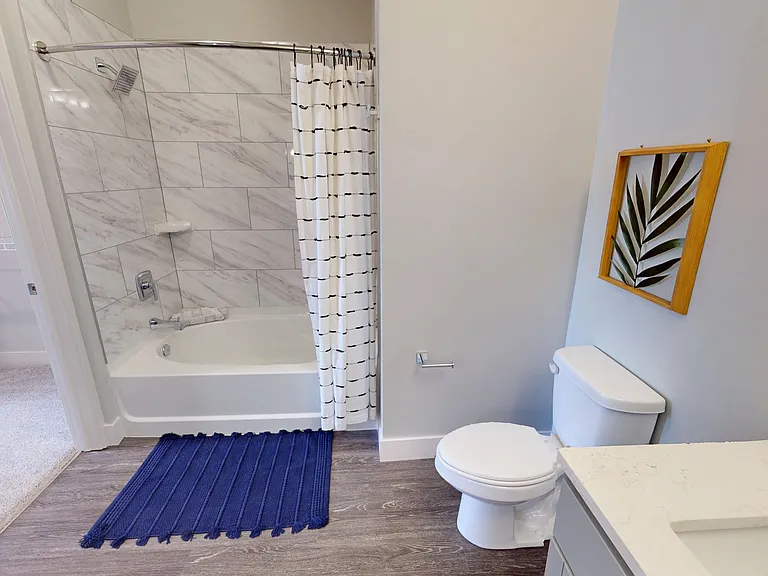 The bathroom of The Oaks floor plan includes a shower with a large bathtub, quartz vanity sink, and connects to the bedroom via a walk-in closet. The bathroom of The Oaks floor plan includes a shower with a large bathtub, quartz vanity sink, and connects 