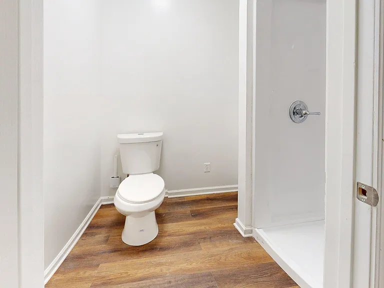 Clean half-bath with a standard toilet, neutral walls, and durable wood-look flooring for easy upkeep.