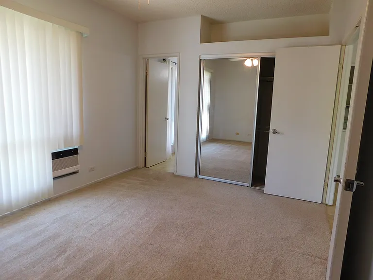 Bedroom #1. Mirrored closet, window a/c. Toward full bathroom.