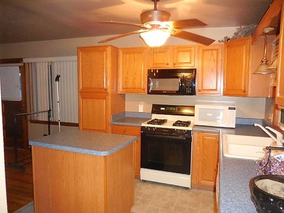 Kitchen view with movable island and oak cabenits