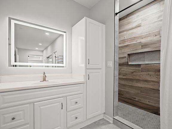 Luxurious Main Bathroom with walk-in shower, extra cabinet space and LED mirror.