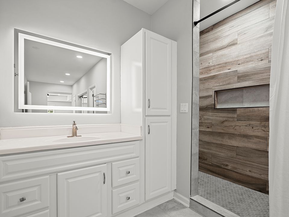 Luxurious Main Bathroom with walk-in shower, extra cabinet space and LED mirror.