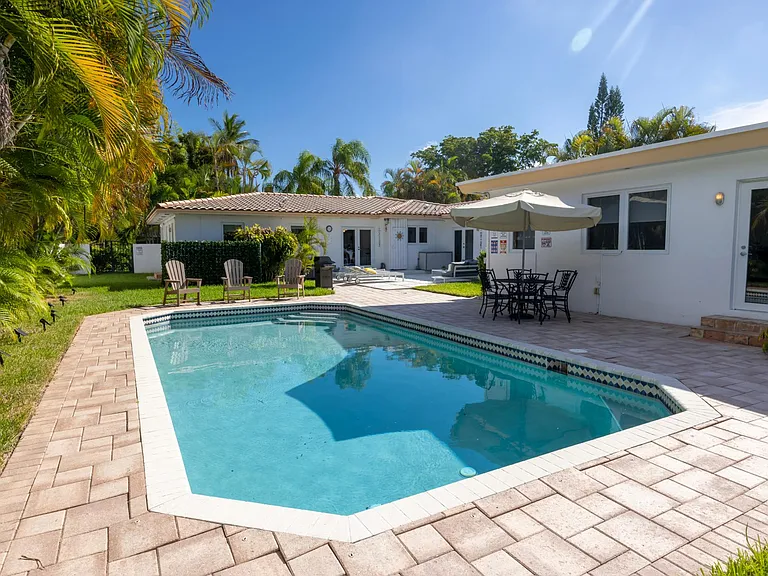 Double sized private fully fenced lot with patio, outdoor dining table, and heated pool.