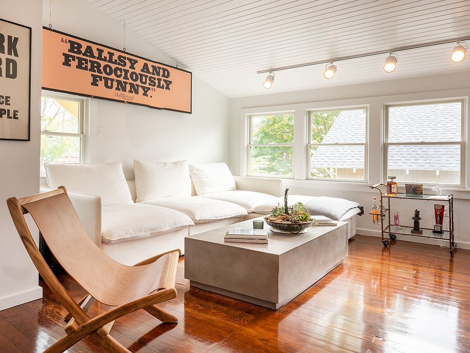 Second floor loft space includes large couch seating area with TV, half bath and a desk.