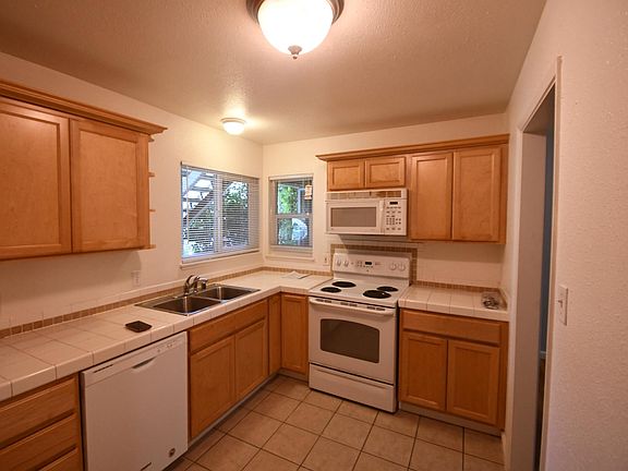 Kitchen has electric range, dishwasher, and built-in microwave