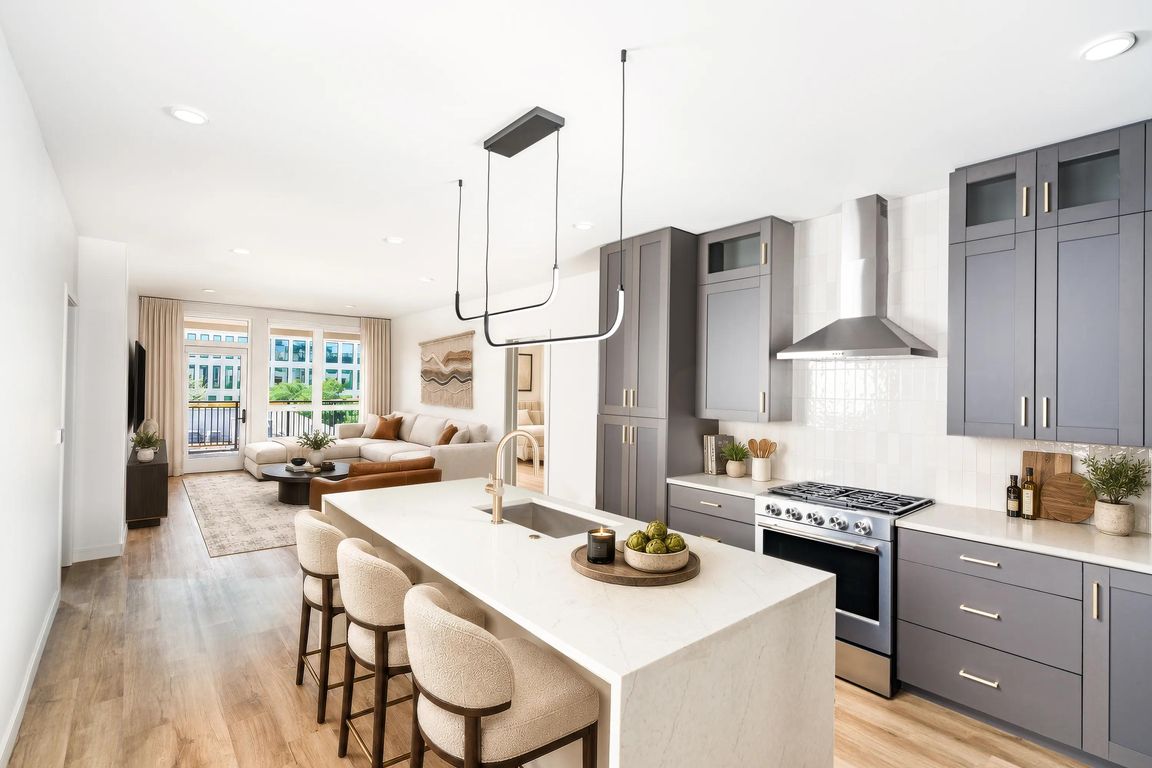 Gourmet kitchens feature quartz waterfall islands, contemporary cabinetry, stainless steel appliances, and designer lighting that seamlessly connect to expansive open-concept living spaces.