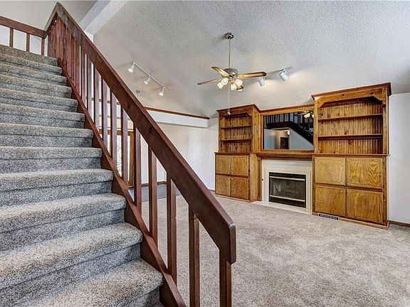 Built in wood cabinets has plenty of storage for photos, books and collectibles