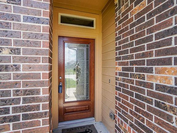 Enter the home through the leaded glass and wood door. There is also another window over the door to let in more natural sunlight.