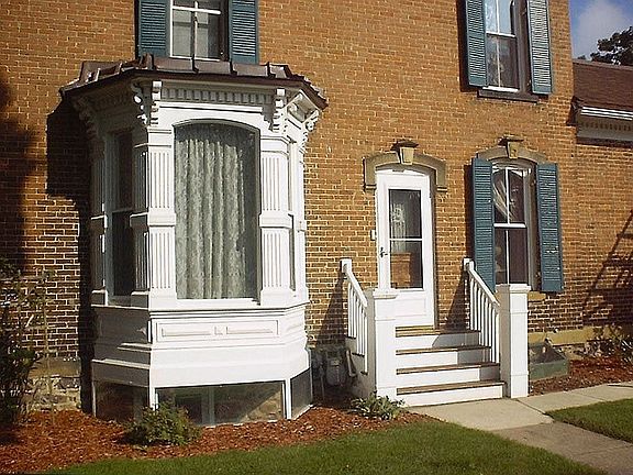 Side entrance with original hitching post.