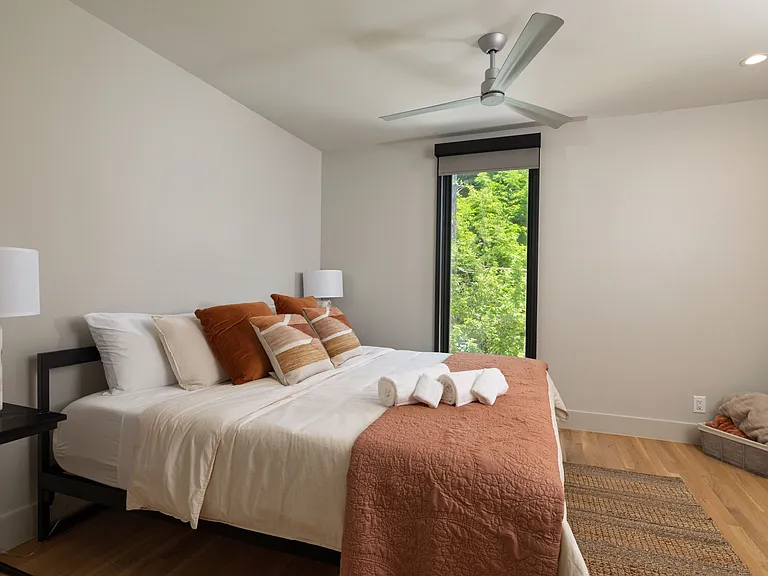 Primary bedroom with king bed, attached bathroom and ceiling fan.