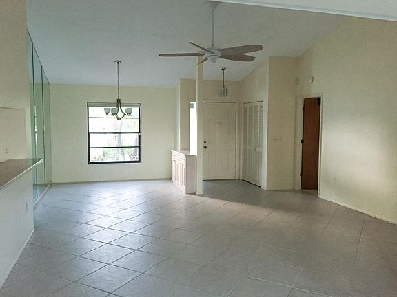 view of living and dining area from sliders to pool.