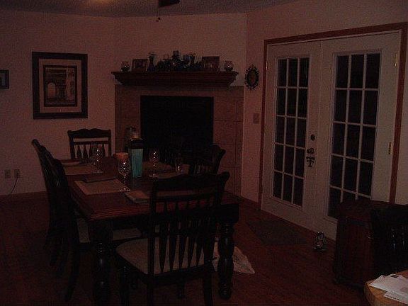 Dining room with hardwood floors, tile fireplace, and french doors to backyard