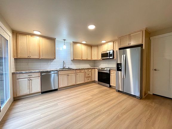 Large kitchen with choices for table placement or adding your own freestanding island. Counter to cabinet tile and a whimsical coutertop. Stainless steel appliances and loads of storage.