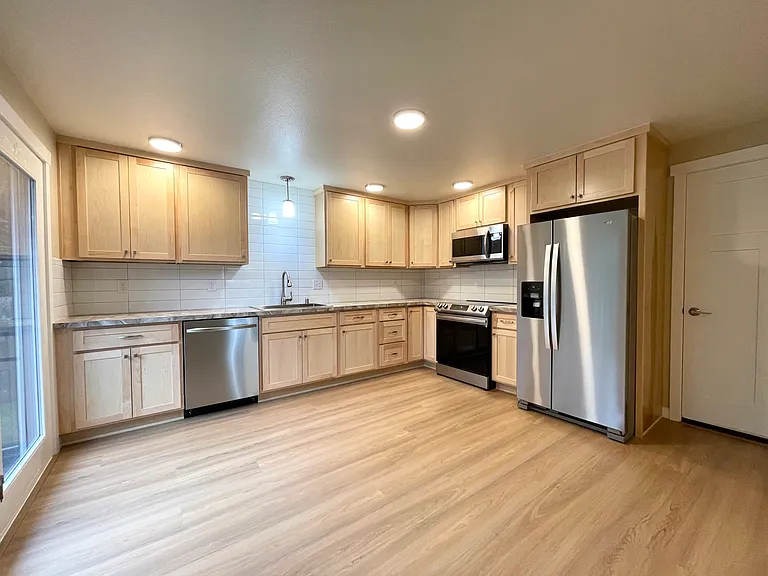 Large kitchen with choices for table placement or adding your own freestanding island. Counter to cabinet tile and a whimsical coutertop. Stainless steel appliances and loads of storage.