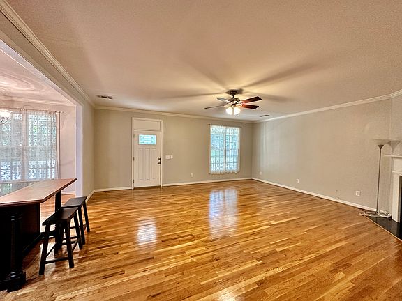 Big open living room and kitchen with a kichen island with two stools