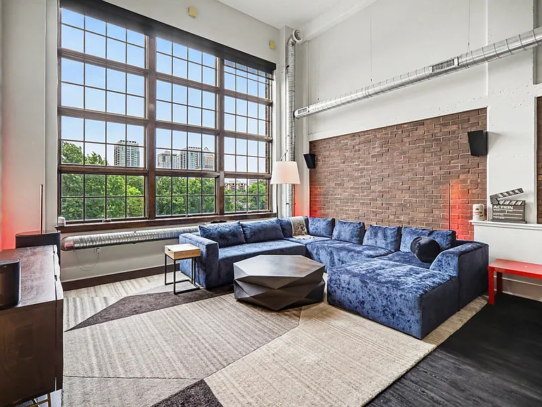 Exposed brick accent walls with big, plush sectional