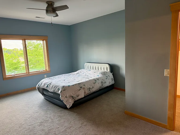 Primary bedroom with large walk in closet and attached ADA bathroom with heated tile floors and roll in shower! New carpet!