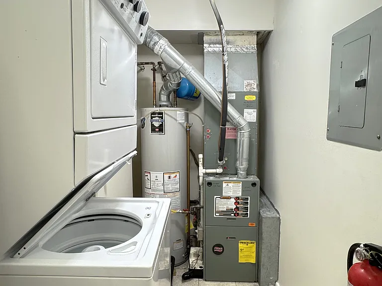 Spacious utility room affords additional storage and houses industrial washer/dryer and newer hot water heater and furnace