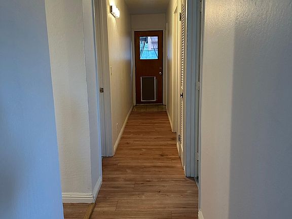 Hallway leads to kitchen, bedrooms and back bathroom.