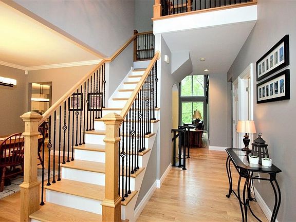 Two story entry foyer with hardwood floors and fresh paint.