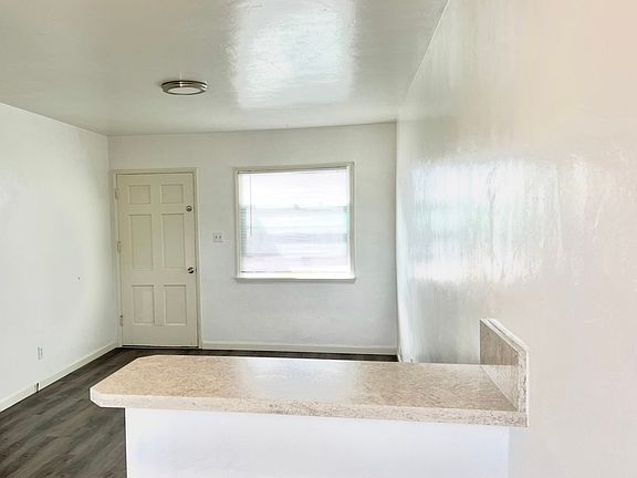 Living Room with Large Window and Breakfast Bar at Kitchen Entry Area