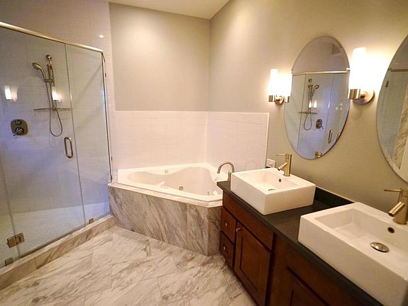 2 Shower heads + rain shower + jacuzzi tube + double sinks + separate door for the toilet + fan. This is the master bathroom en suite. There is a small private window in both the shower and the W.C.