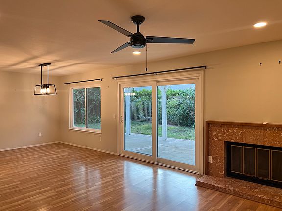 Living room with marble fireplace and dining room with updated chandelier.