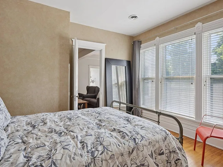Second angle of the bedroom, showing floor-to-ceiling south-facing windows. Best views in the neighborhood. Door walks into the living room.