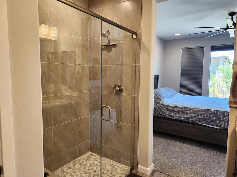 Primary bathroom with tiled shower and a bench