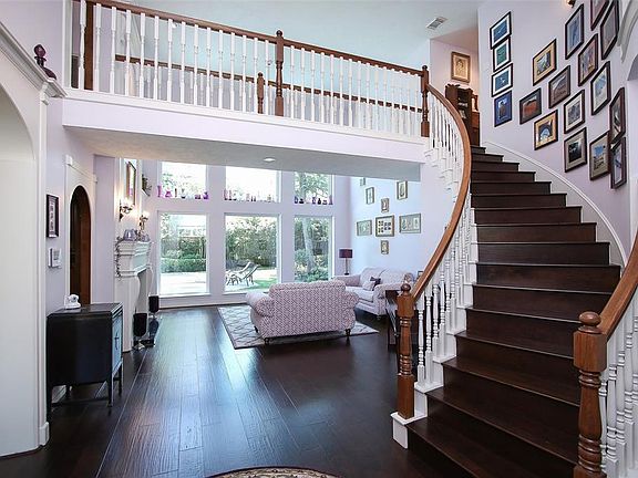 Stunning Entry with 20ft. ceilings, new hardwood flooring, with a sweeping staircase and cat walk. Overlooking the wall of picturesque bay windows with a view of the backyard, pool, and spa.