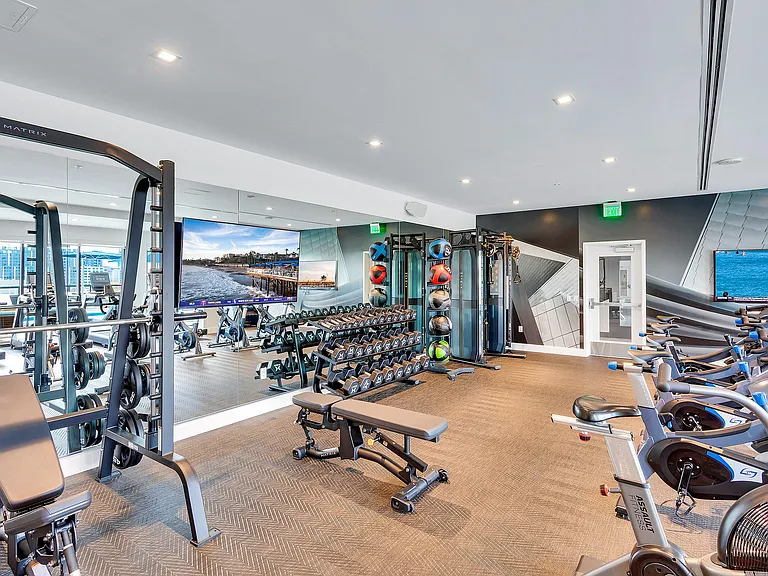 Modern fitness center with state-of-the-art equipment, sleek weight racks, and vibrant decor for an energizing workout experience.