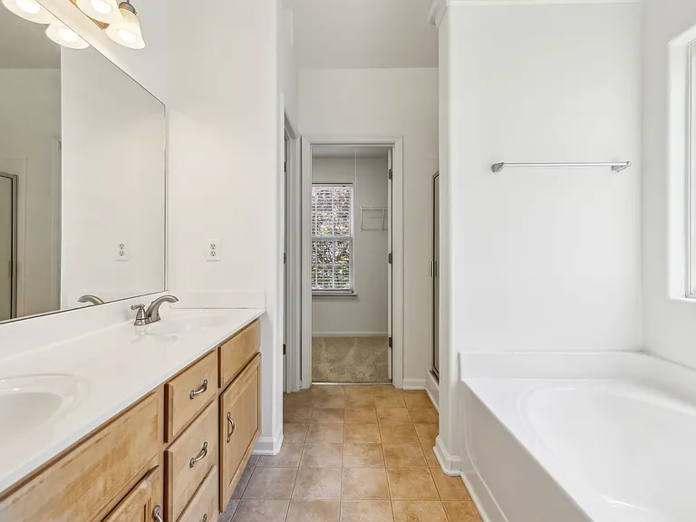 primary bathroom with soaking tub and walk in shower and walk-in closet