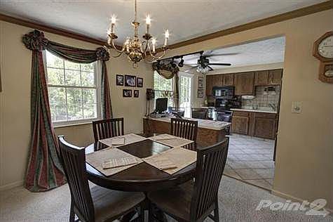 This cheerful yet elegant dining room offers crown molding, a single view window overlooking the parklike backyard and a full view of the kitchen with counterbar.
