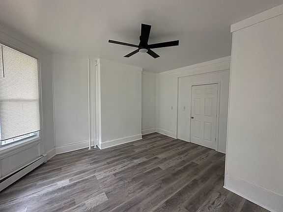 Large street view bedroom with ceiling fan