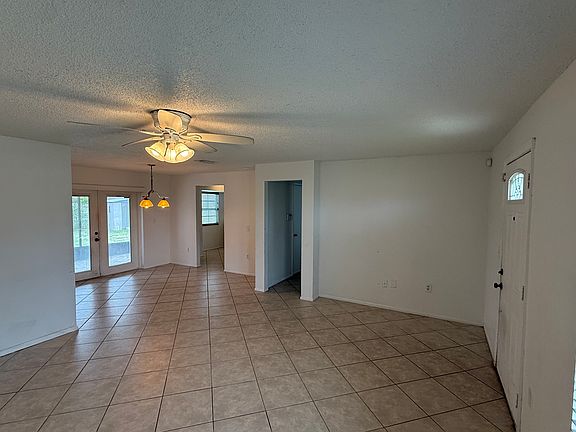 living room, looking toward patio and kitchen door, and second bedroom hallway
