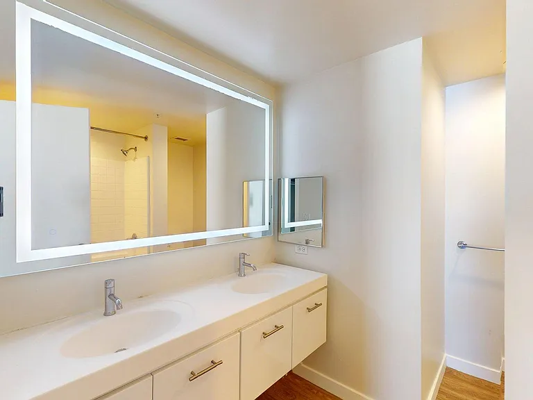 Apartment Bathroom with large soaking tub, LED vanity mirror and Wood-Style Flooring.
