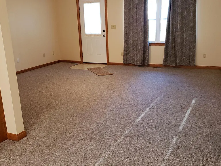 View of living room from dining room, lines in carpet are from the sun