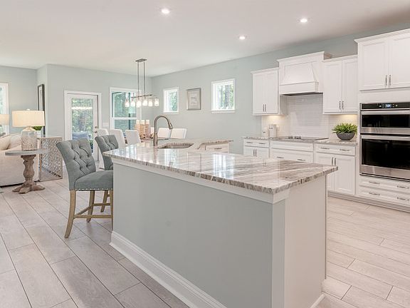 Gourmet Kitchen with Stainless Steel Double Wall Oven and Large Island.