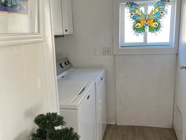 laundry room with butterfly stained glass, overhead cabinets 
and table