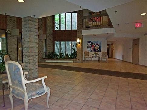 Airy, inviting secure building lobby with elevator access to garage and upper floors.