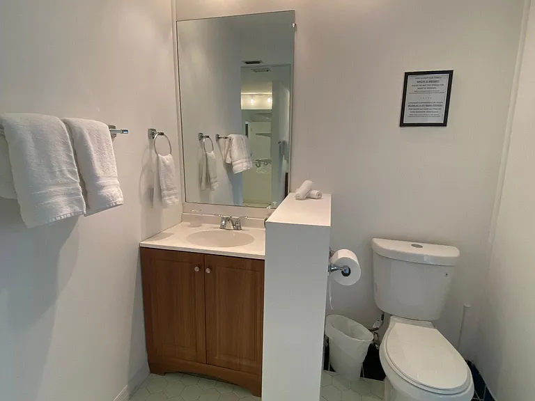 Pristine bathroom with shower, sink, toilet, and essential amenities.