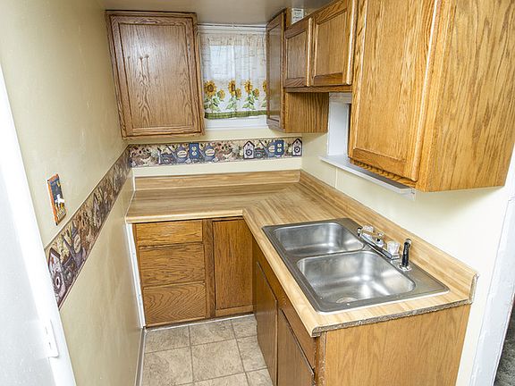 Kitchen (6x12)  has nice oak cabinets, stainless steel sink, vinyl flooring and a pass through window convenient to the dining room.