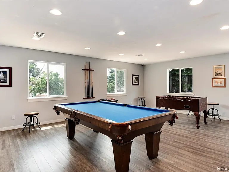 Community clubhouse game room with billiards table and foosball table