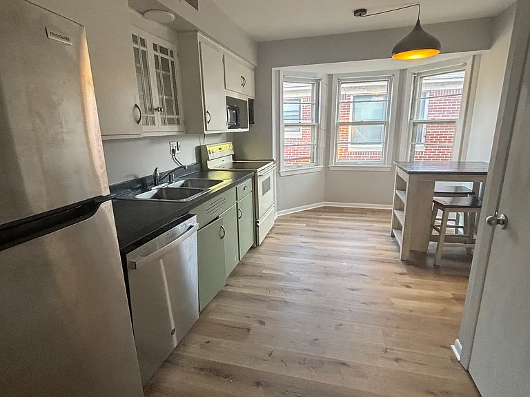 Brand new flooring in kitchen with updated appliances. Island with stools included.